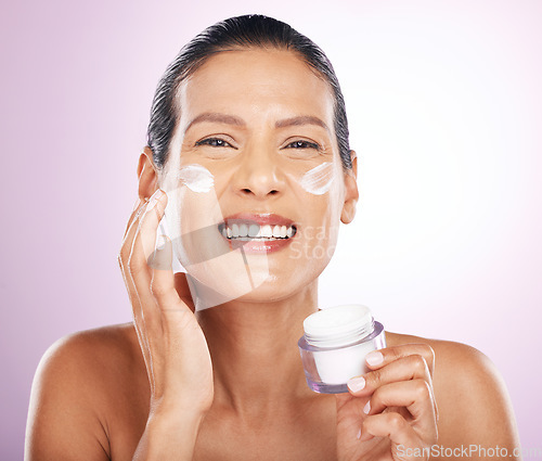 Image of Face, cream jar and skincare of woman in studio isolated on a purple background. Mature, portrait and happy female model with dermatology lotion, creme and moisturizer cosmetics for healthy skin.