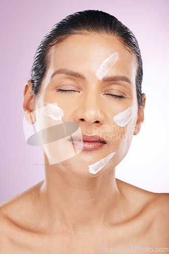 Image of Face, cream and skincare of woman with eyes closed in studio isolated on a purple background. Mature, cosmetics and female with dermatology lotion, creme or moisturizer for healthy skin or anti aging