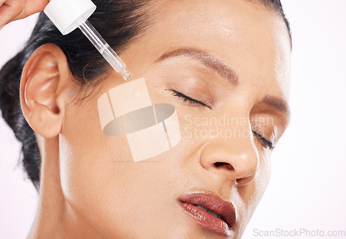 Image of Face, skincare serum and woman with eyes closed in studio isolated on a purple background. Dermatology, cosmetics and mature female model apply hyaluronic acid, retinol or essential oil for antiaging