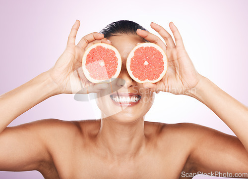 Image of Face smile, grapefruit and skincare of woman in studio isolated on a purple background. Natural cosmetics, food and happy mature female model with fruit for vitamin c, nutrition and healthy diet.