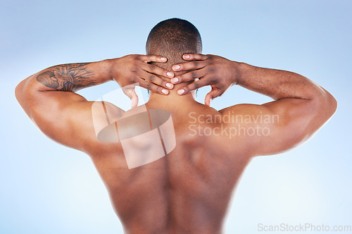 Image of Back, muscle and black man touching neck or head as self love, skincare and isolated in a studio blue background. Health, wellness and strong muscular bodybuilder or model embracing skin