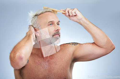 Image of Mature man, haircare or brush for grooming in a studio with a model doing morning beauty routine. Wellness lifestyle, hairstyle care and male with hairdresser comb on an isolated grey background