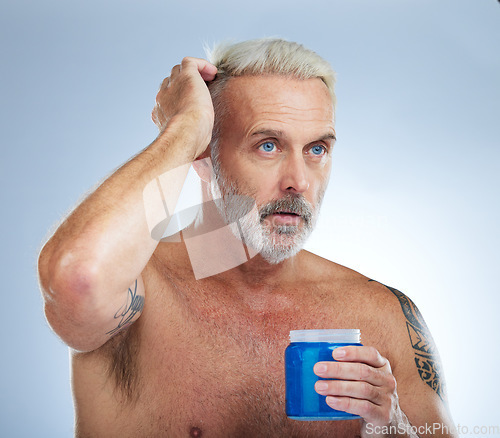 Image of Hair care, grooming and mature man with gel isolated on a blue background in studio. Beauty, clean and a senior man with a product for styling, hairstyle and applying balm for a hairdo on a backdrop