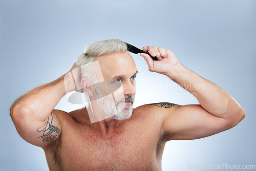 Image of Mature man, brush hair and scalp health treatment in a studio with a model doing beauty routine. Wellness lifestyle, hairstyle care and male with hairdresser comb with an isolated grey background