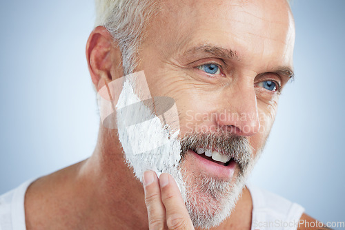 Image of Mature man, face and shaving cream for grooming, skincare or hair removal against studio background. Closeup of senior male applying shave creme, cosmetics or product for haircare or facial treatment