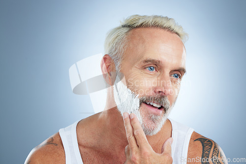 Image of Senior man, shaving cream and smile for grooming, skincare or hair removal against a studio background. Face of mature male applying shave creme, cosmetics or product for haircare or facial treatment