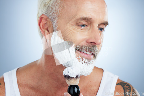 Image of Senior man, beard and shaving cream for skincare, grooming or hair removal against studio background. Mature male face applying shave creme or foam product with brush for haircare or facial treatment