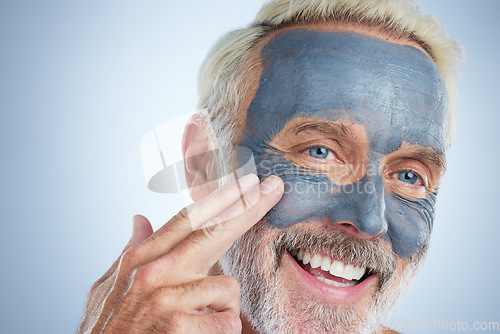 Image of Senior man, skin and face mask in studio for health, wellness and organic cleaning with smile by background. Elderly male, hand and natural charcoal product for facial cosmetics for dermatology detox