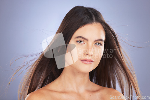 Image of Woman, beauty and hair for studio portrait with wind, growth and healthy shine on blue background. Aesthetic female model face for skincare, self care and haircare cosmetics for salon or hairdresser