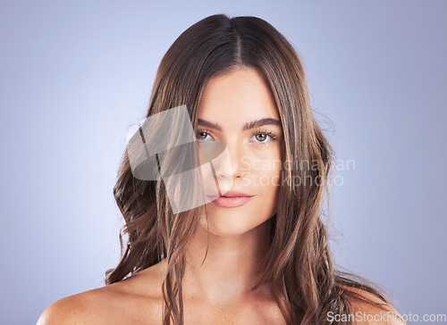 Image of Woman, beauty portrait and hair care in studio for curls, growth and healthy shine on blue background. Aesthetic female model face for skincare, haircare and cosmetic results for salon or hairdresser