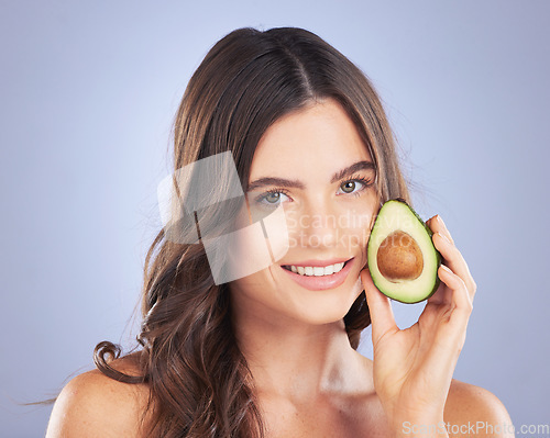 Image of Woman, avocado and skincare in studio portrait with smile, organic cosmetics and nutrition for beauty. Girl, model and fruit for cosmetic, skin and natural healthy glow with pride by blue background