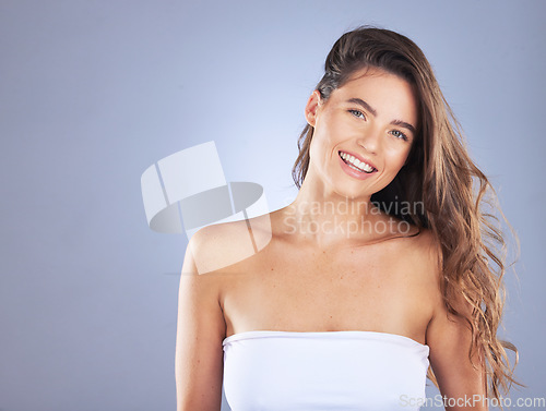 Image of Woman portrait, beauty and hair care space in studio for curls, growth and shine on blue background. Aesthetic female model smile for haircare, skincare and cosmetic mockup for salon or hairdresser