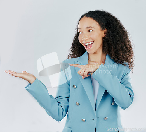 Image of Business woman, pointing and studio with palm for mockup, promotion or space by white background. Happy entrepreneur, smile and open hand for product placement, mock up or happiness for company promo