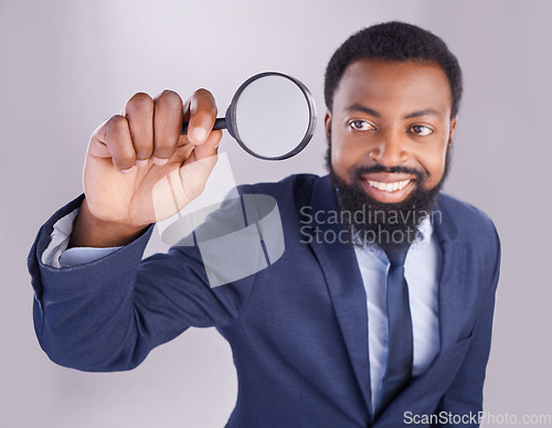 Image of Corporate black man, magnifying glass and studio with smile for quality inspection, compliance and fair trade. Businessman, inspector and audit at company with attention for financial health at job