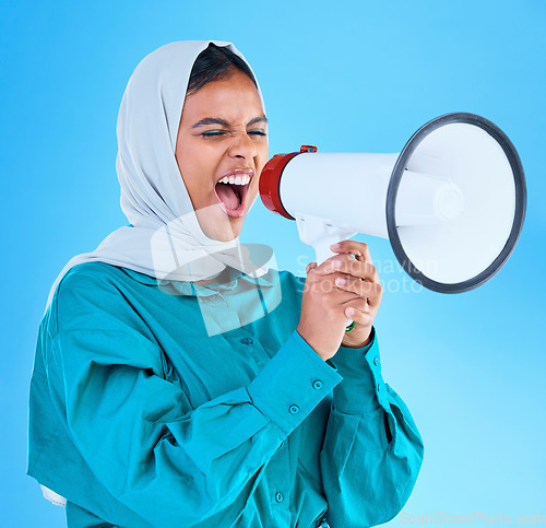 Image of Young woman, muslim and megaphone in studio for protest, human rights and scream by blue background. Girl, islam and loudspeaker for speech, justice and vote for freedom, mission and power politics