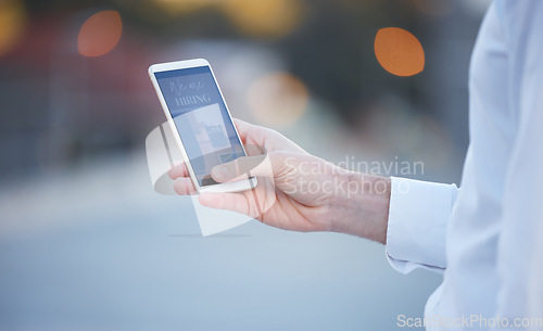 Image of Hand, smartphone screen and city for job, opportunity or search on recruitment website for work. Man, mobile phone ux and company with we are hiring banner, human resources advertising or career goal