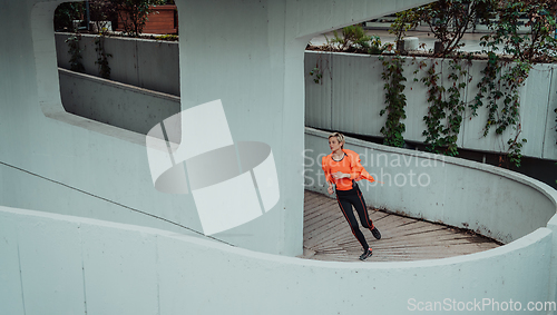 Image of Women in sports clothes running in a modern urban environment. The concept of a sporty and healthy lifestyle