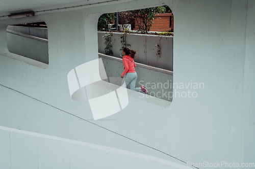 Image of Women in sports clothes running in a modern urban environment. The concept of a sporty and healthy lifestyle