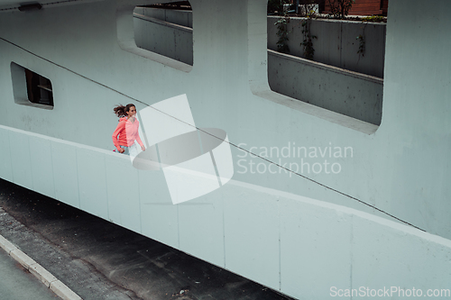 Image of Women in sports clothes running in a modern urban environment. The concept of a sporty and healthy lifestyle