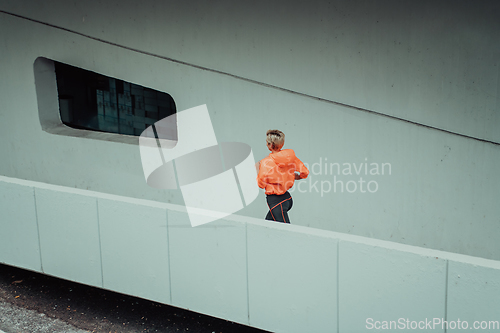 Image of Women in sports clothes running in a modern urban environment. The concept of a sporty and healthy lifestyle