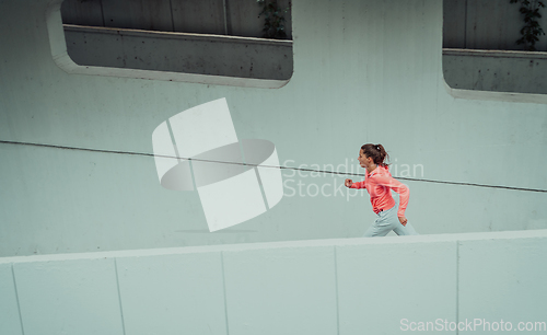 Image of Women in sports clothes running in a modern urban environment. The concept of a sporty and healthy lifestyle