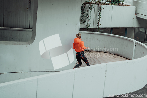 Image of Women in sports clothes running in a modern urban environment. The concept of a sporty and healthy lifestyle