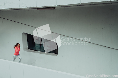 Image of Women in sports clothes running in a modern urban environment. The concept of a sporty and healthy lifestyle