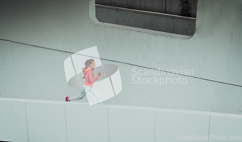 Image of Women in sports clothes running in a modern urban environment. The concept of a sporty and healthy lifestyle