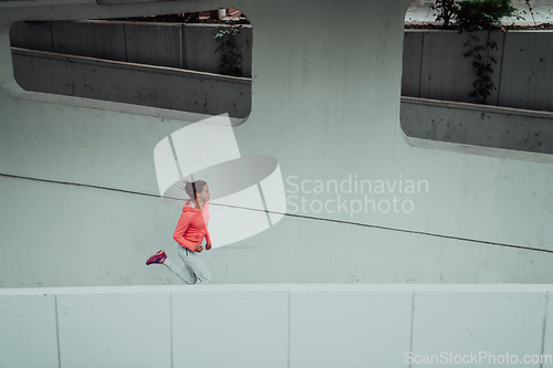 Image of Women in sports clothes running in a modern urban environment. The concept of a sporty and healthy lifestyle