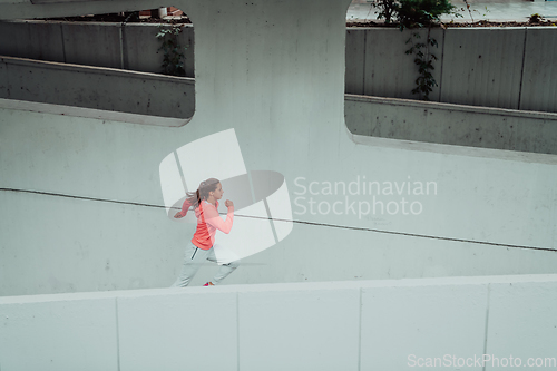 Image of Women in sports clothes running in a modern urban environment. The concept of a sporty and healthy lifestyle