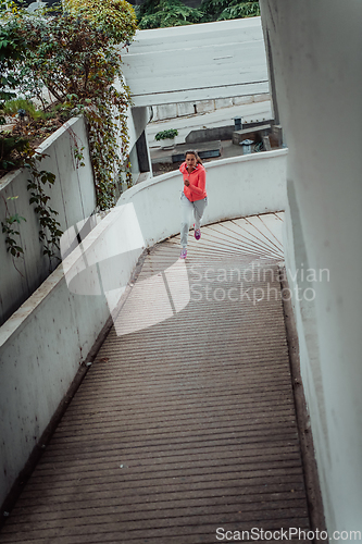 Image of Women in sports clothes running in a modern urban environment. The concept of a sporty and healthy lifestyle