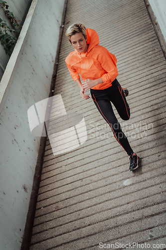 Image of Women in sports clothes running in a modern urban environment. The concept of a sporty and healthy lifestyle