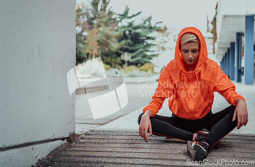 Image of Two women in sports clothes running in a modern urban environment. The concept of a sporty and healthy lifestyle