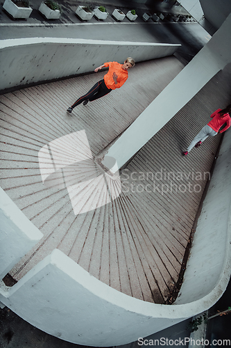 Image of Two women in sports clothes running in a modern urban environment. The concept of a sporty and healthy lifestyle