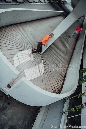 Image of Two women in sports clothes running in a modern urban environment. The concept of a sporty and healthy lifestyle