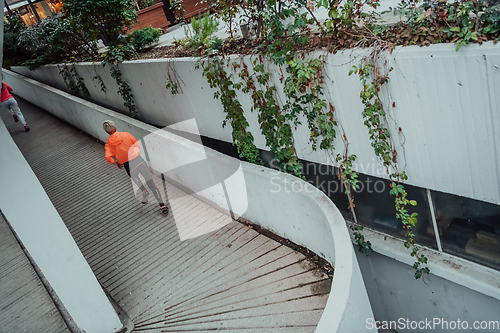 Image of Two women in sports clothes running in a modern urban environment. The concept of a sporty and healthy lifestyle