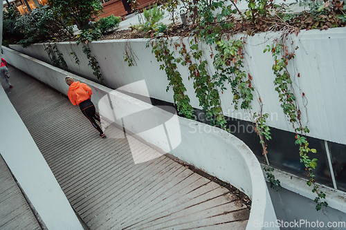 Image of Two women in sports clothes running in a modern urban environment. The concept of a sporty and healthy lifestyle