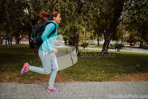 Image of Women in sports clothes running in a modern urban environment. The concept of a sporty and healthy lifestyle