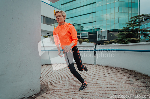 Image of Women in sports clothes running in a modern urban environment. The concept of a sporty and healthy lifestyle