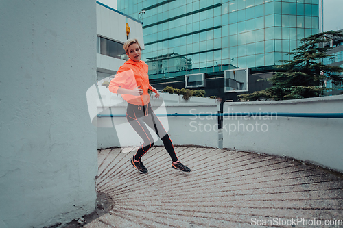 Image of Women in sports clothes running in a modern urban environment. The concept of a sporty and healthy lifestyle