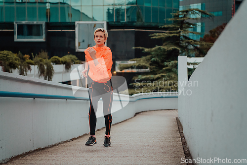 Image of Women in sports clothes running in a modern urban environment. The concept of a sporty and healthy lifestyle