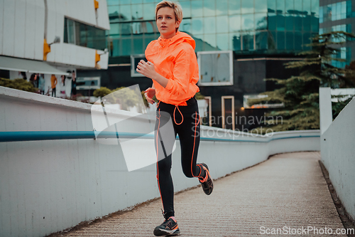 Image of Women in sports clothes running in a modern urban environment. The concept of a sporty and healthy lifestyle