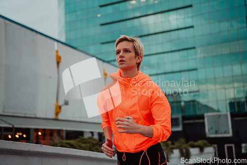 Image of Women in sports clothes running in a modern urban environment. The concept of a sporty and healthy lifestyle