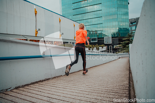 Image of Women in sports clothes running in a modern urban environment. The concept of a sporty and healthy lifestyle