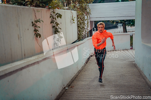 Image of Women in sports clothes running in a modern urban environment et night time. The concept of a sporty and healthy lifestyle