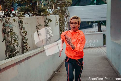 Image of Women in sports clothes running in a modern urban environment et night time. The concept of a sporty and healthy lifestyle