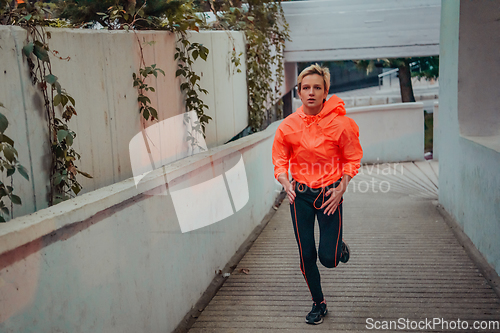 Image of Women in sports clothes running in a modern urban environment et night time. The concept of a sporty and healthy lifestyle