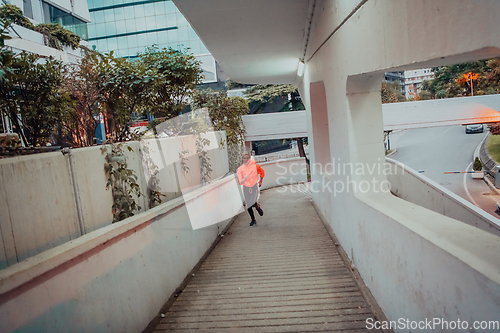 Image of Women in sports clothes running in a modern urban environment et night time. The concept of a sporty and healthy lifestyle