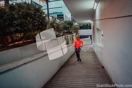 Image of Women in sports clothes running in a modern urban environment et night time. The concept of a sporty and healthy lifestyle