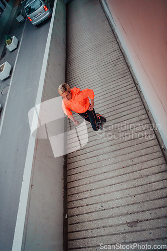 Image of Women in sports clothes running in a modern urban environment et night time. The concept of a sporty and healthy lifestyle